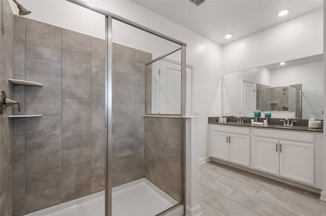 bathroom featuring a shower with door, tile patterned flooring, and vanity