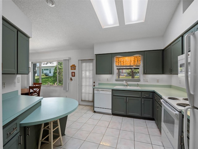 kitchen with a textured ceiling, white appliances, sink, and light tile patterned floors