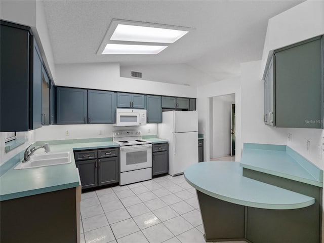 kitchen with a textured ceiling, white appliances, lofted ceiling with skylight, sink, and light tile patterned flooring