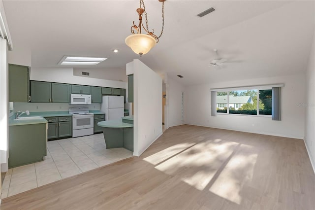 kitchen with ceiling fan, hanging light fixtures, green cabinets, lofted ceiling with skylight, and white appliances