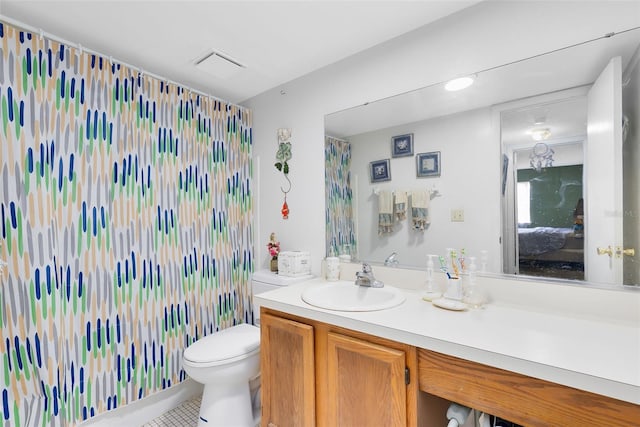 bathroom featuring vanity, toilet, and tile patterned flooring