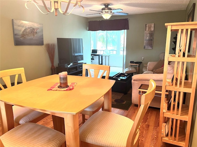 dining space featuring hardwood / wood-style floors, ceiling fan, and a textured ceiling