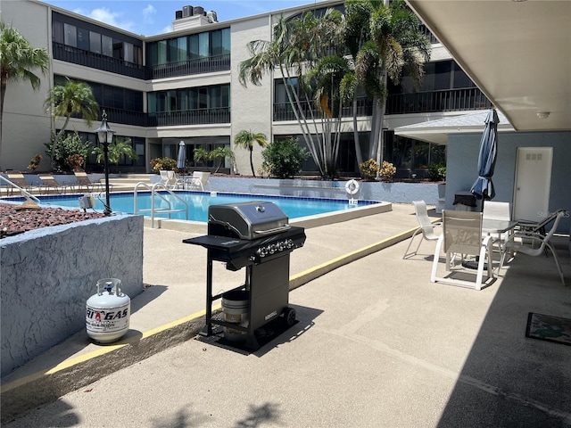 view of swimming pool featuring a grill and a patio area