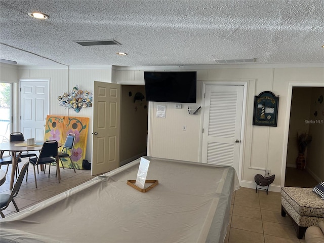 game room with a textured ceiling and tile patterned floors