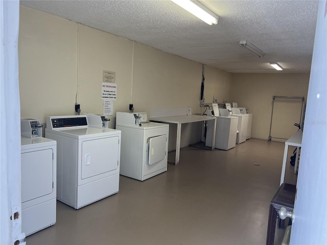 clothes washing area featuring a textured ceiling and washer and dryer