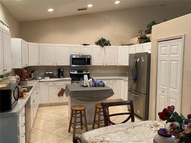 kitchen with light tile patterned floors, white cabinetry, and stainless steel appliances