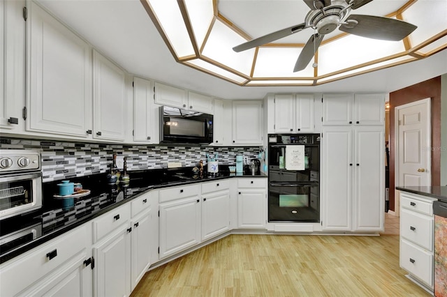 kitchen with light hardwood / wood-style floors, white cabinetry, black appliances, ceiling fan, and tasteful backsplash