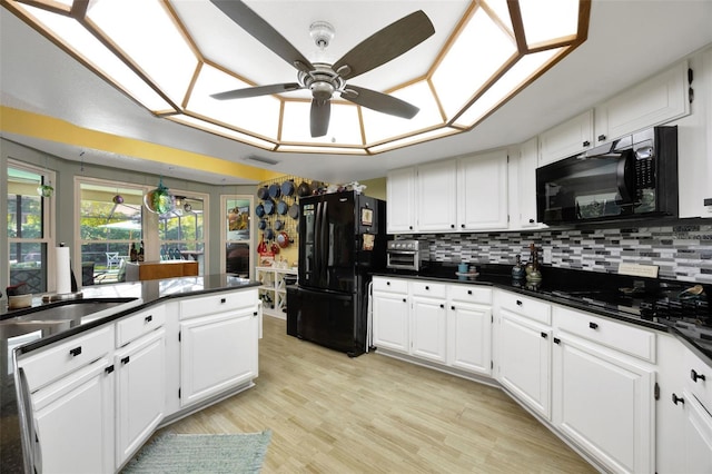 kitchen featuring black appliances, backsplash, and white cabinets