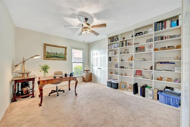 home office with ceiling fan, carpet, and a textured ceiling