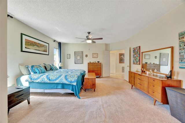 bedroom featuring a textured ceiling, ceiling fan, and light carpet