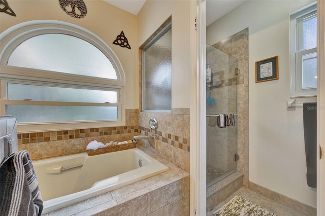 bathroom with separate shower and tub and tile patterned flooring