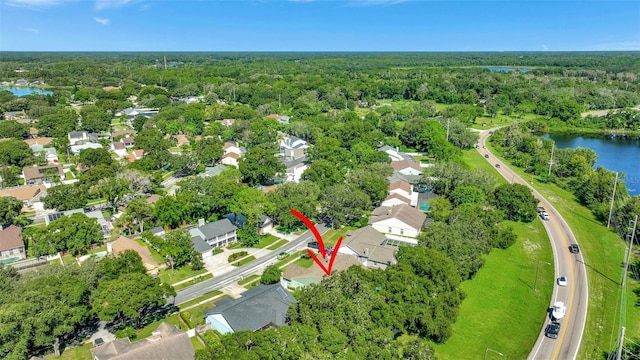 birds eye view of property featuring a forest view, a water view, and a residential view