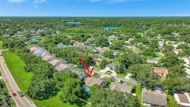 birds eye view of property with a residential view, a wooded view, and a water view