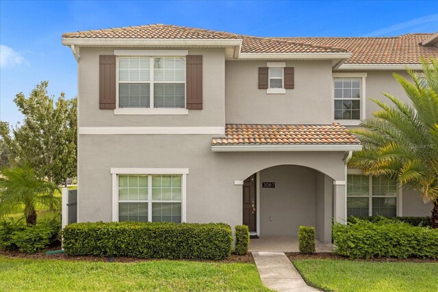 mediterranean / spanish house with a front lawn