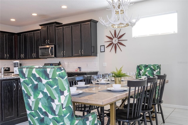 dining area with sink, a chandelier, and light tile patterned flooring