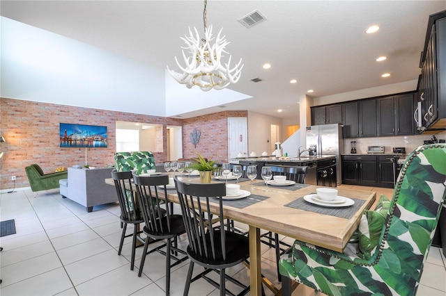 dining room with light tile patterned floors, an inviting chandelier, and a high ceiling