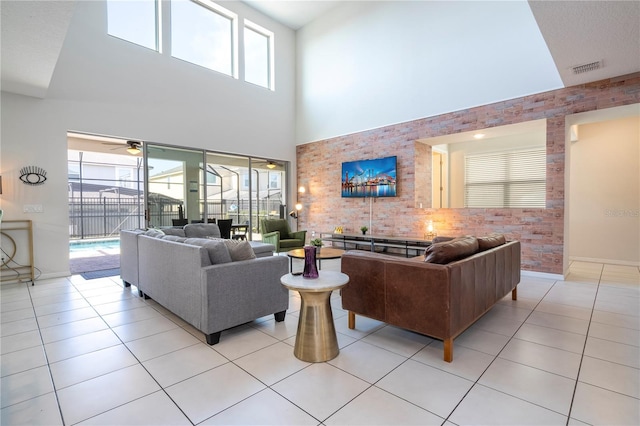 tiled living room with ceiling fan and a towering ceiling