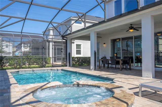 view of pool featuring glass enclosure, a patio area, and an in ground hot tub