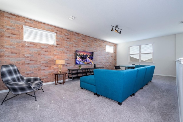 carpeted living room featuring brick wall