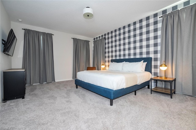 bedroom featuring light carpet and a textured ceiling