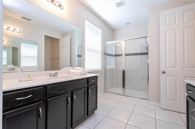 bathroom featuring vanity, tile patterned floors, and a shower with door