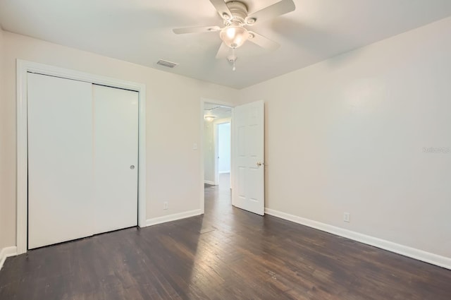 unfurnished bedroom featuring a closet, ceiling fan, and dark hardwood / wood-style flooring