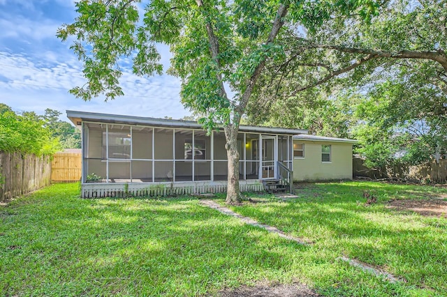 back of property featuring a sunroom and a yard