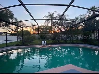 view of pool with a fenced in pool, glass enclosure, and a patio