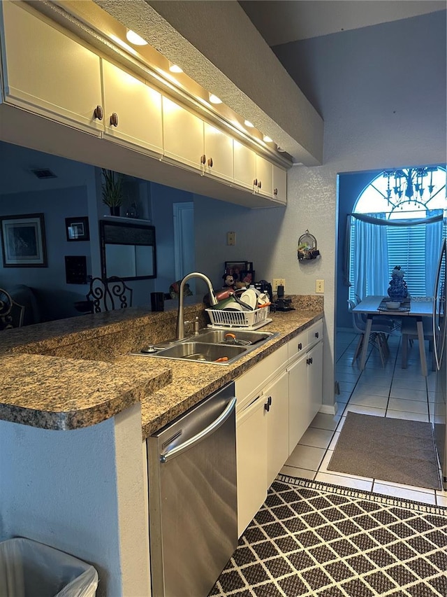 kitchen with a sink, dishwasher, white cabinets, and light tile patterned floors