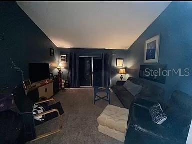 carpeted living area with vaulted ceiling