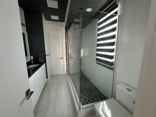 bathroom featuring tile patterned floors, vanity, a shower, and toilet