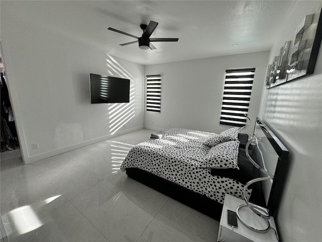 tiled bedroom with baseboards, multiple windows, and ceiling fan