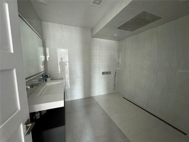 bathroom featuring walk in shower, tile patterned flooring, and vanity