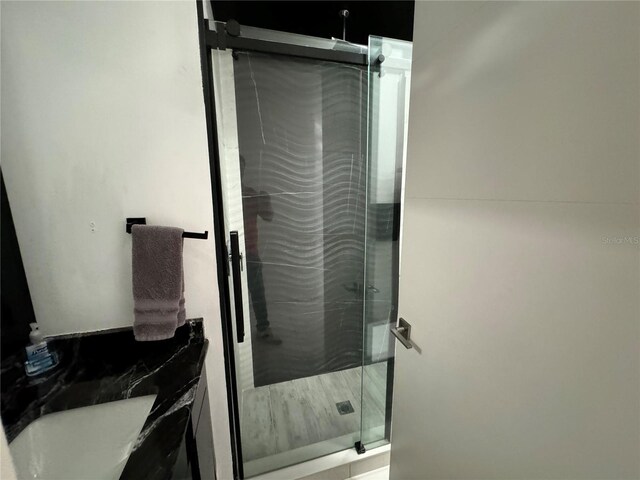 bathroom featuring a shower with door