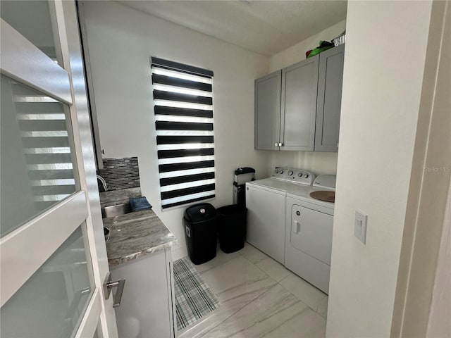 laundry room with cabinet space, marble finish floor, and separate washer and dryer