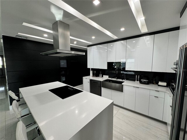 kitchen featuring a center island, sink, white cabinets, range hood, and black appliances