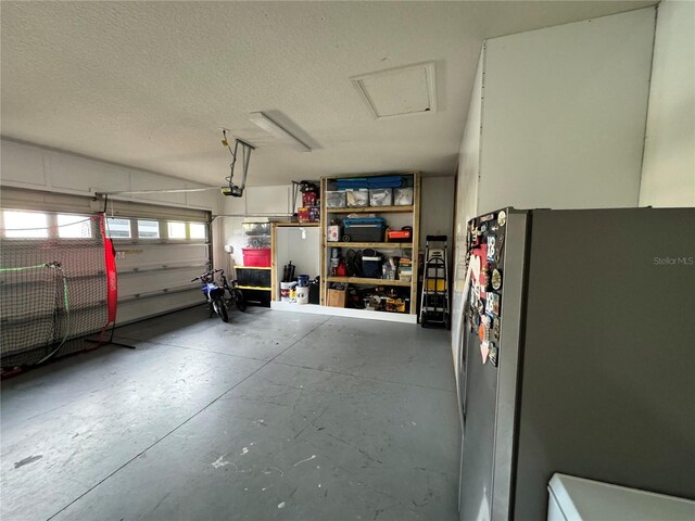 garage featuring a garage door opener and stainless steel fridge