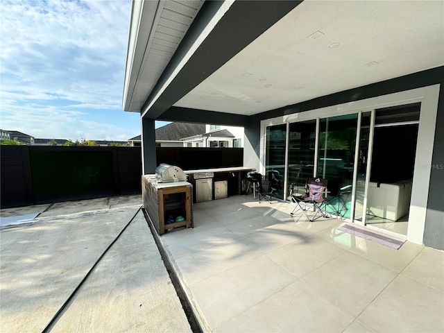 view of patio / terrace with exterior kitchen and fence