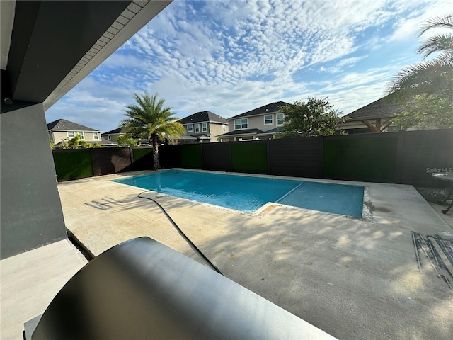 view of pool featuring a residential view, a fenced in pool, a patio, and a fenced backyard