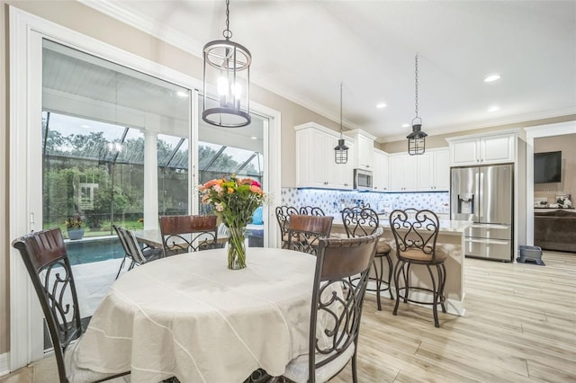 dining room with crown molding and light hardwood / wood-style floors