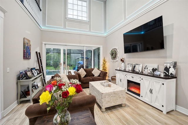 living room featuring light wood-type flooring and a high ceiling