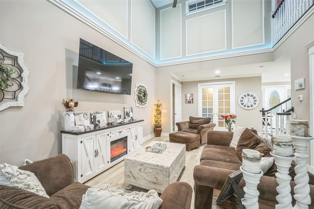 living room featuring light hardwood / wood-style flooring and a towering ceiling