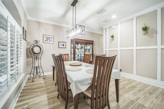 dining area featuring crown molding and light hardwood / wood-style floors