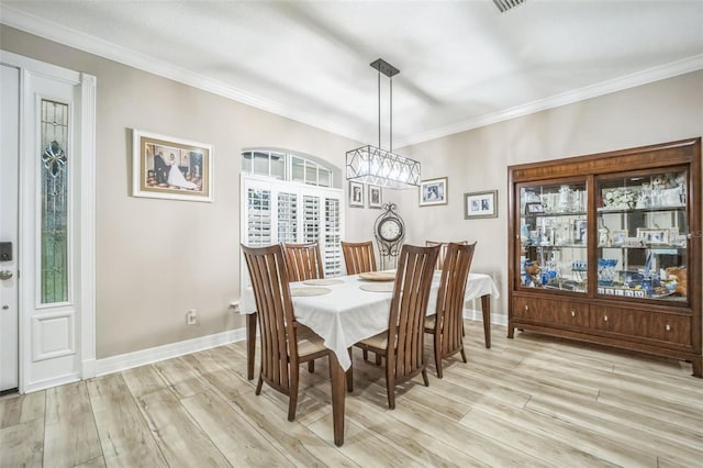 dining space featuring a wealth of natural light, light hardwood / wood-style floors, and crown molding