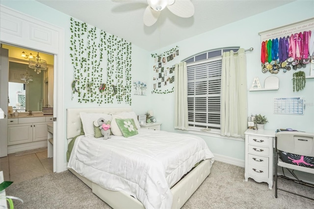 bedroom with ensuite bath, ceiling fan with notable chandelier, light carpet, and sink