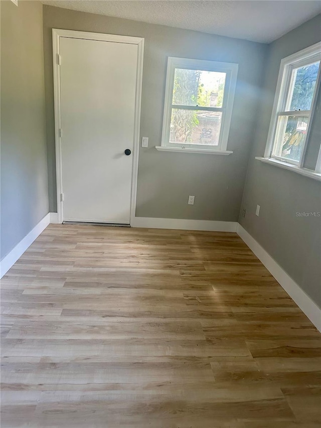 empty room with light wood-type flooring and baseboards