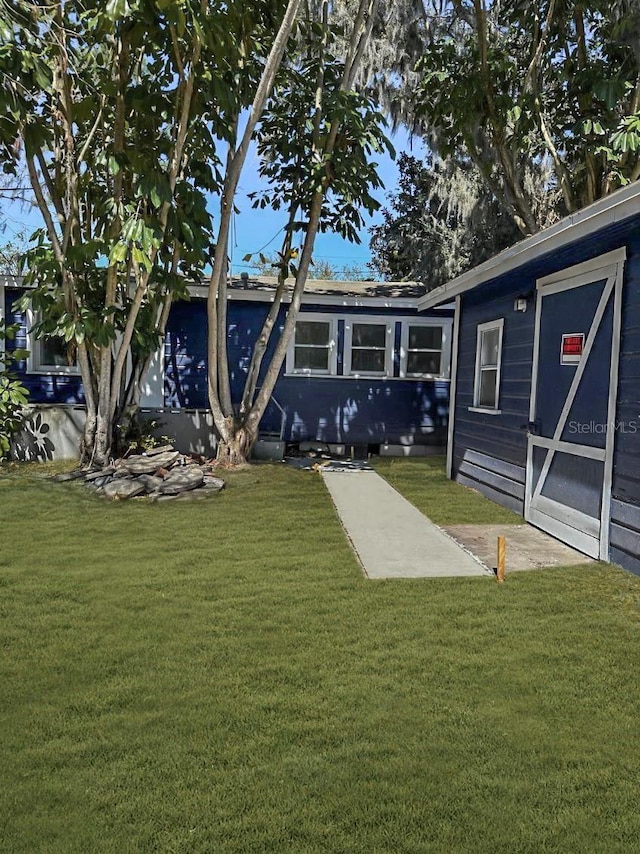 rear view of house featuring a yard