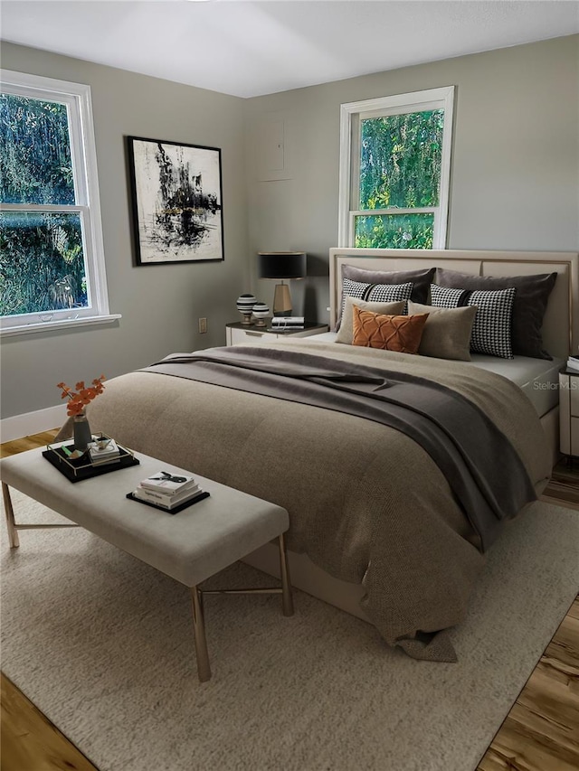 bedroom with multiple windows and wood finished floors