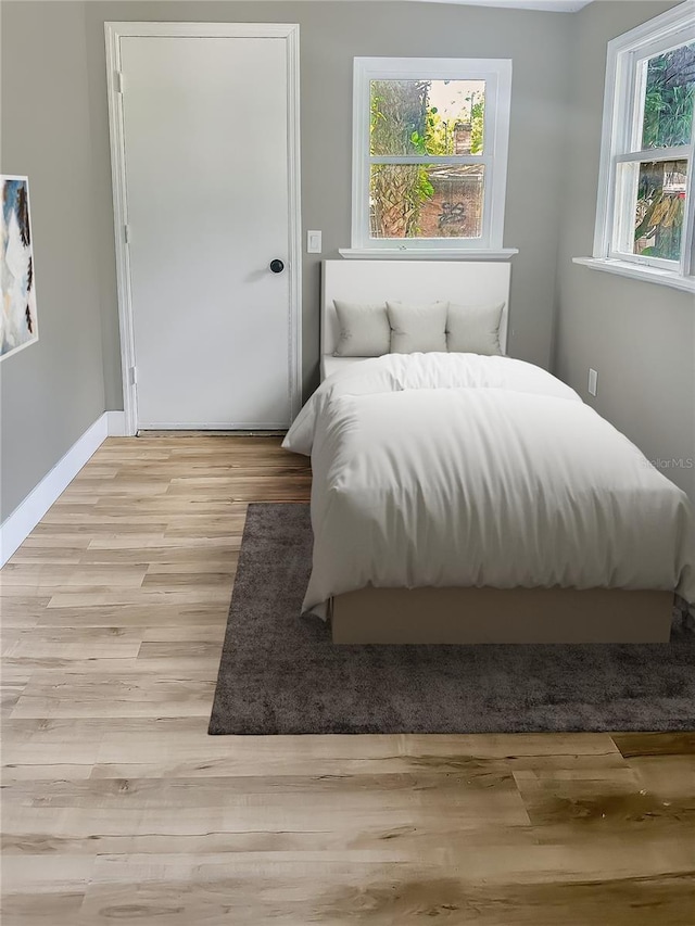 bedroom with baseboards and wood finished floors