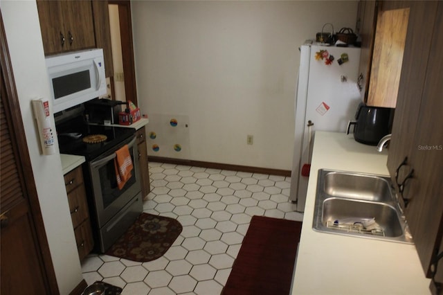 kitchen featuring sink, light tile patterned flooring, and stainless steel range with electric cooktop